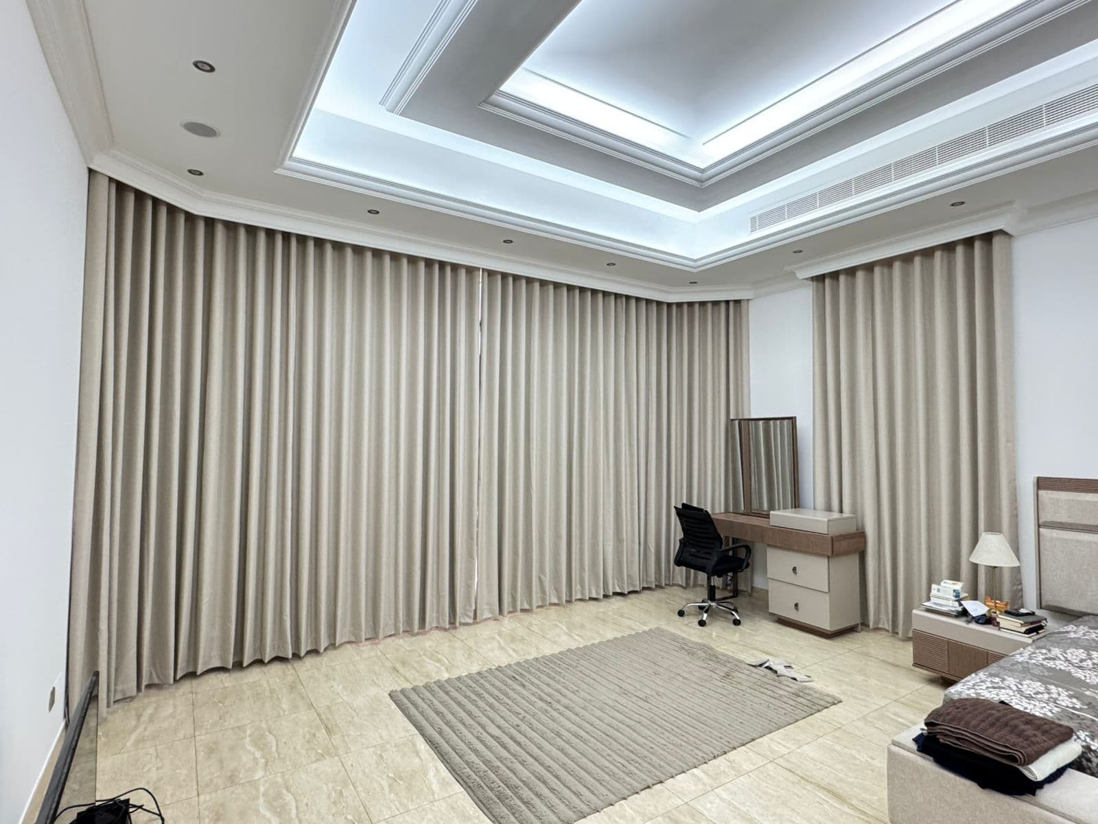 Floor-to-ceiling wave-fold curtains in a contemporary UAE living room