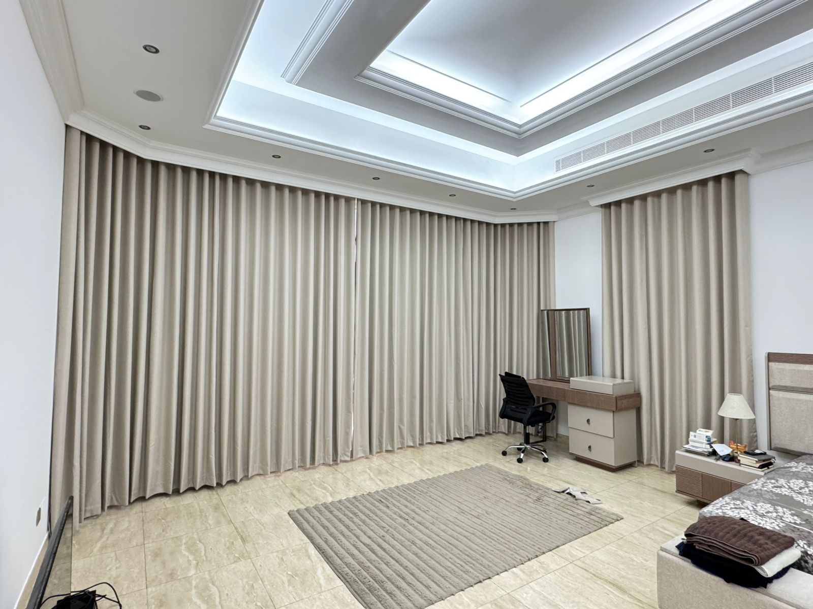 Floor-to-ceiling modern wave-fold drapes in rich burnt orange over a contemporary living lounge