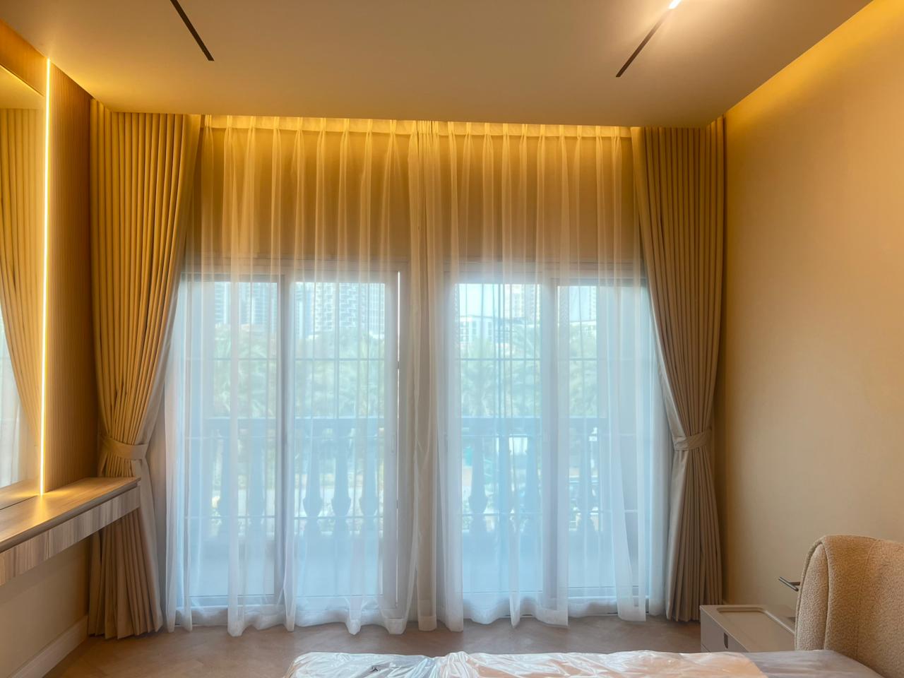 Layered sheer and thick drapes combined in a UAE lounge for light control and privacy